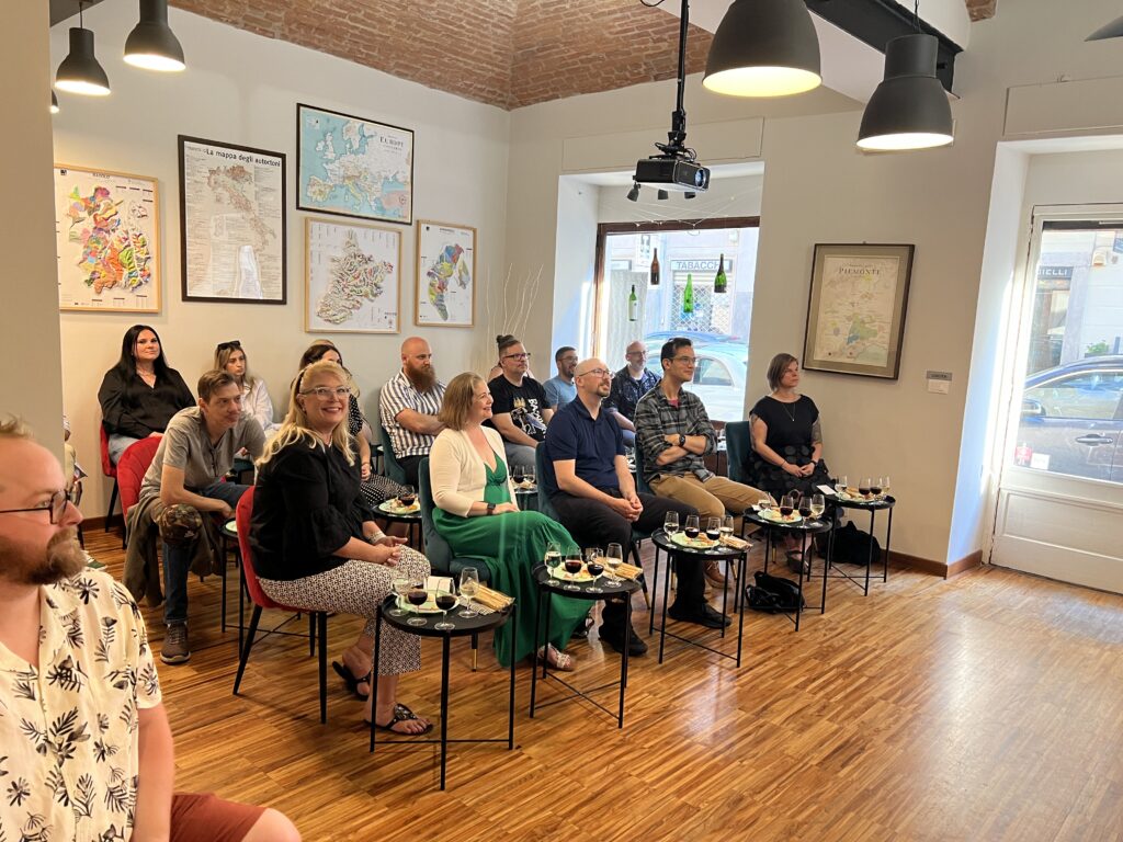 Members of the StellarWP team learning about Italian wines in a small shop in Torino